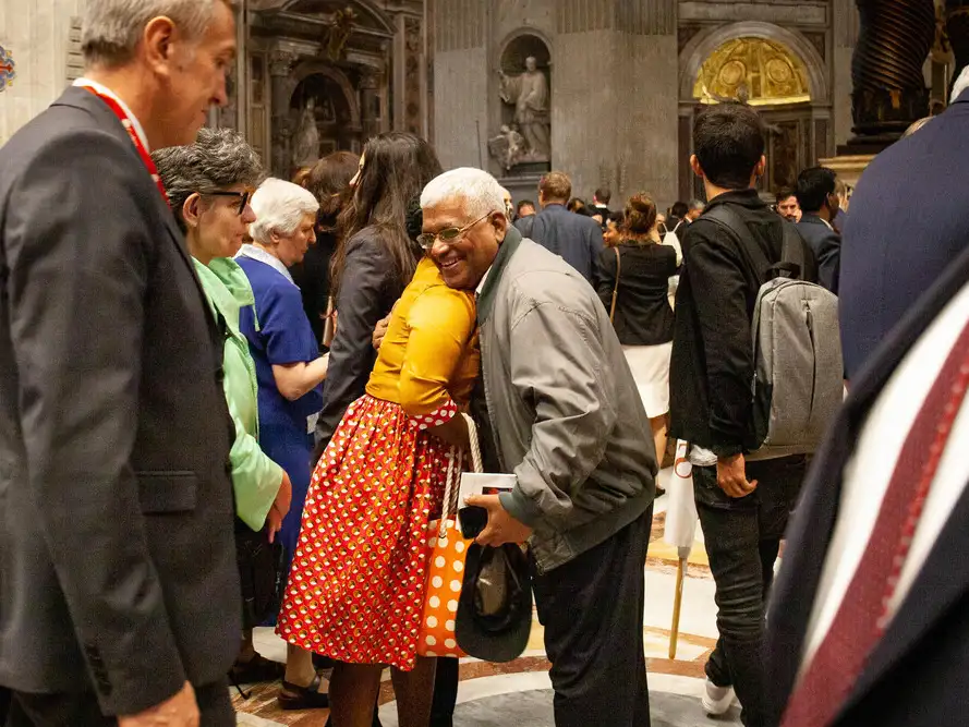Two attendees embrace after a Mass in St Peter's Basilica
